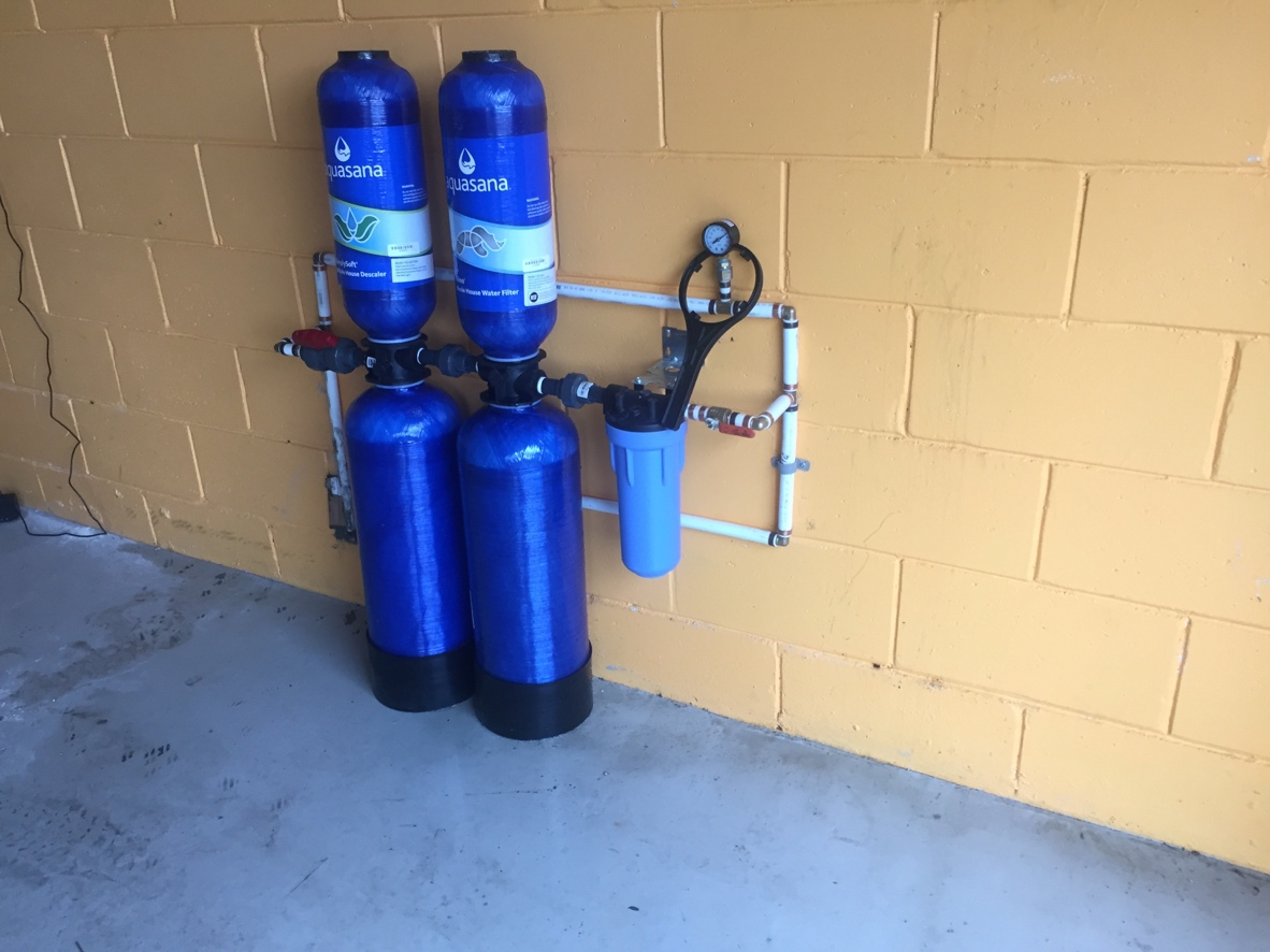 Whole-house water filter and salt-free descaler mounted in a garage